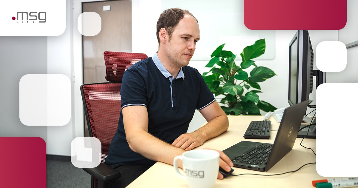 Programmierer arbeitet hinter einem Computer im msg life Büro